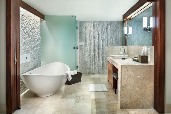 This image shows a modern bathroom with a large freestanding bathtub, a glass shower enclosure, and a vanity with a sink and mirror.