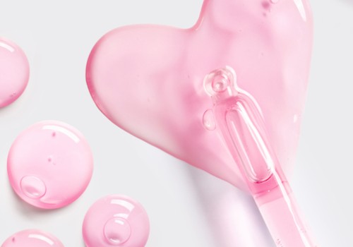 Two pink heart-shaped soaps or gels with a clear pink dropper, glossy and soft, on a light background, playful and dreamy.