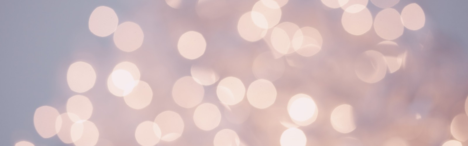 This image shows soft, blurry lights in warm tones, creating a bokeh effect with circular light spots against a neutral background, creating a dreamy feel.
