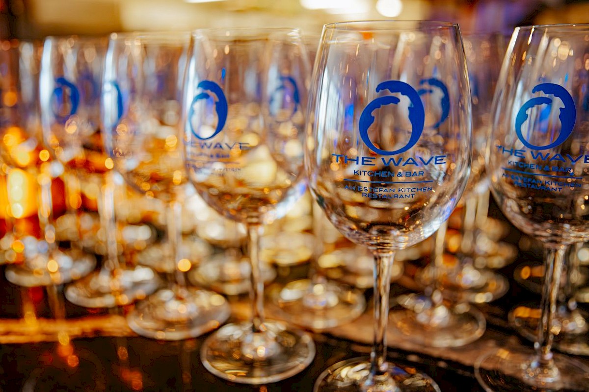 Several empty wine glasses with the logo of 