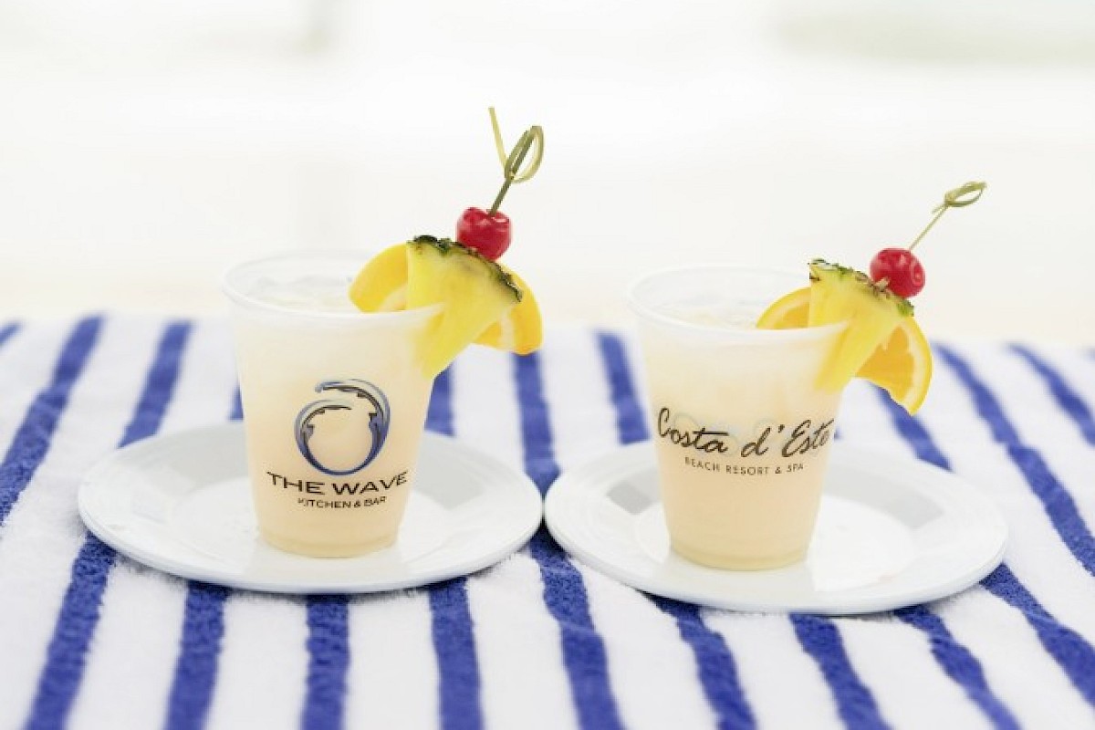 Two tropical cocktails with lemon, cherry, and pineapple garnishes, labeled 
