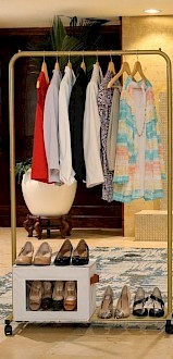 A clothing display with dresses, tops, and heels, encouraging women to make an impact and empower others by leaving a 