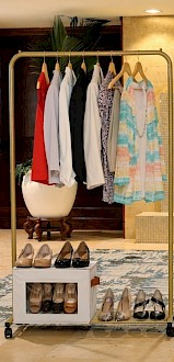 A clothing display with dresses, tops, and heels, encouraging women to make an impact and empower others by leaving a 