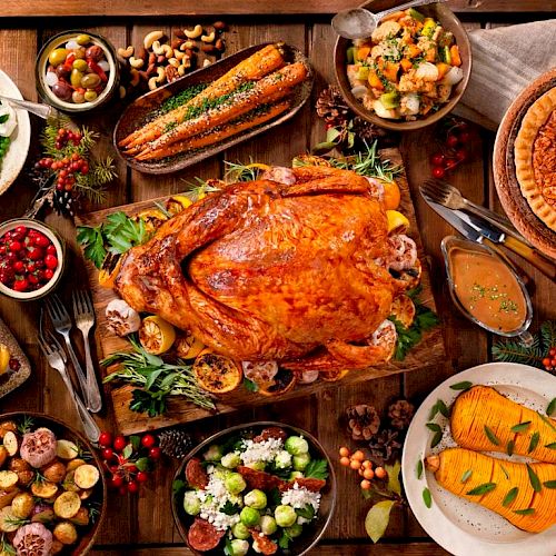 A roasted turkey with various side dishes such as mashed potatoes, stuffing, salads, corn, cranberry sauce, roasted vegetables, and pumpkin pie.