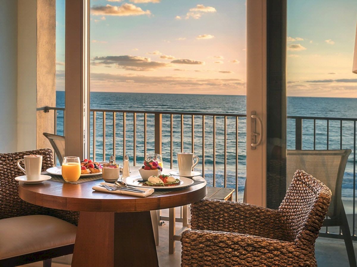 A cozy breakfast setup with an ocean view from a balcony.