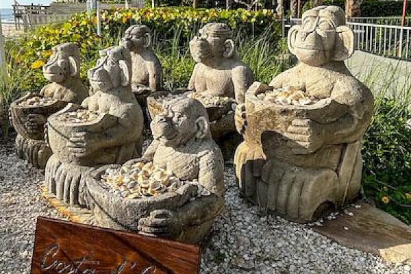 Stone sculptures of various animals and mythical creatures are displayed outdoors with a 