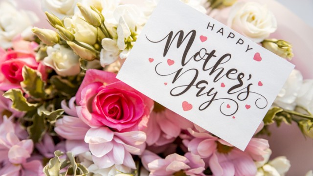 A bouquet of pink and white flowers with a “Happy Mother’s Day” card tucked among them.