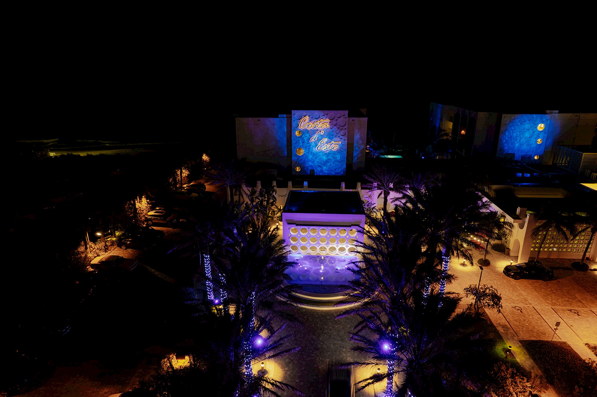 This image shows a nighttime scene with vibrant lights, highlighting an outdoor area with signs reading 