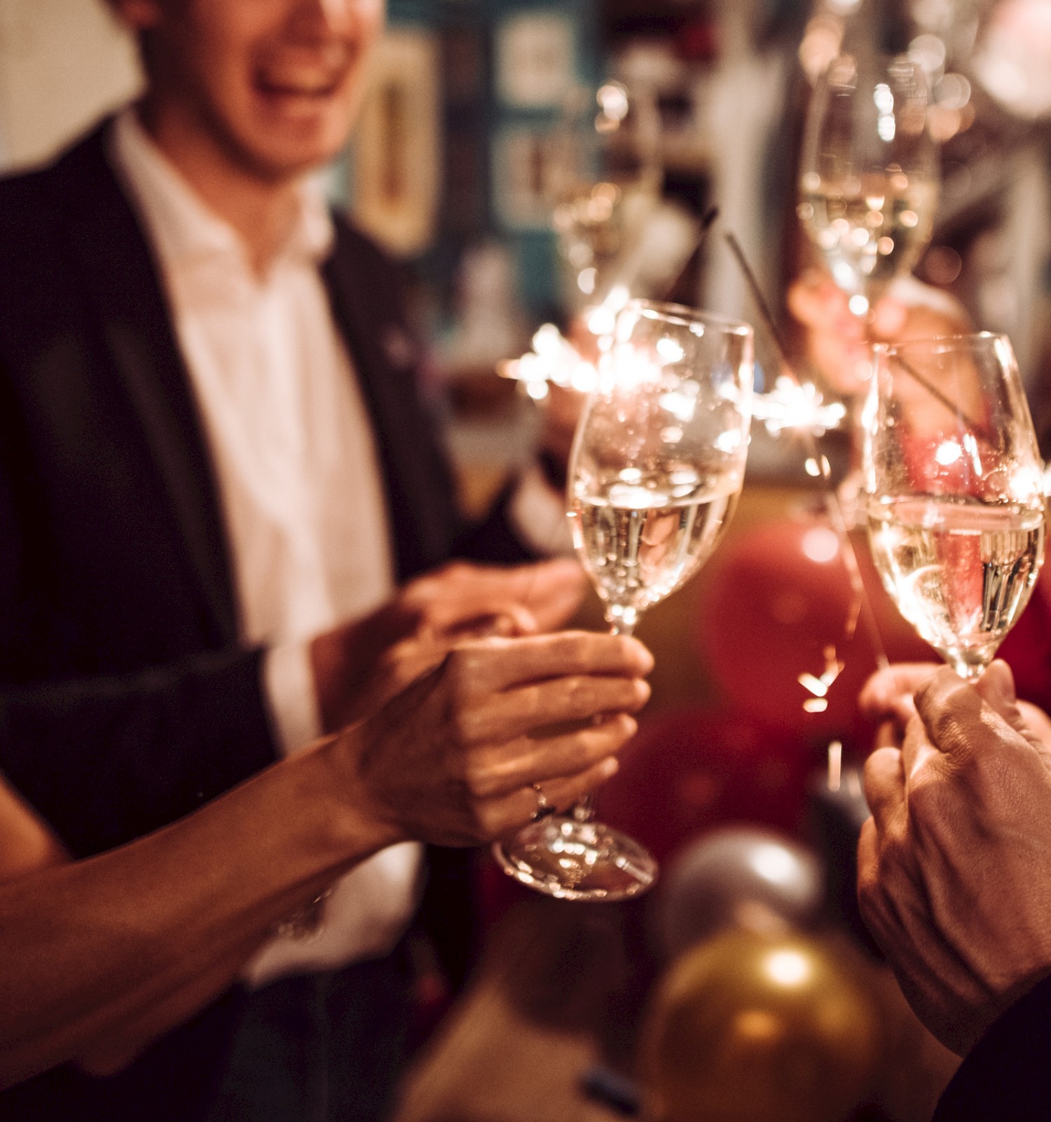 People are celebrating with champagne and sparklers, raising glasses in a festive toast.