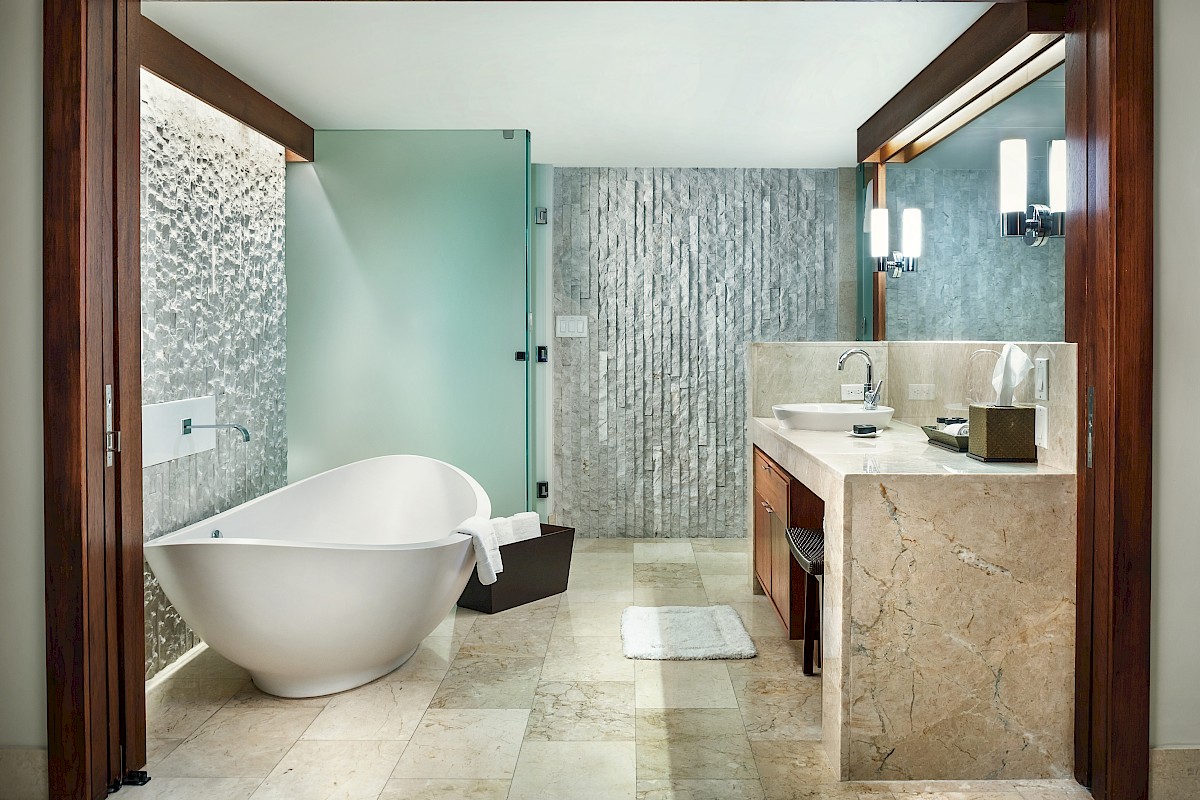 Luxurious bathroom with a freestanding tub, glass shower, marble sink, and stylish lighting.