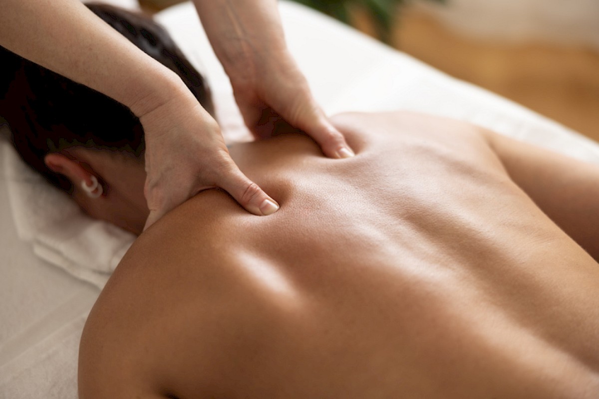 A person is receiving a massage on their back in a spa or massage therapy setting.