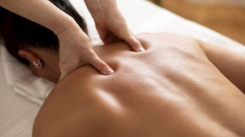 A person is receiving a massage on their back in a spa or massage therapy setting.