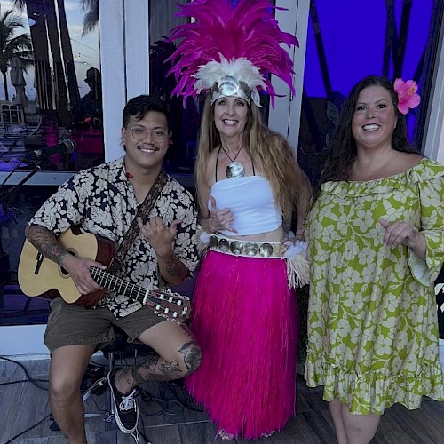 Josiah Nalzaro guitar player with 2 hawaiian dancers